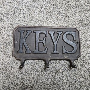 Heavy metal antique key hanger. 3 hooks. Hangs on wall.
